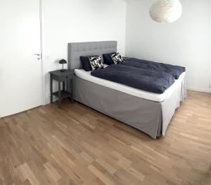 a bedroom with a bed and a wooden floor at Modern home in Helsingborg in Helsingborg