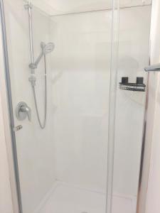 a shower in a bathroom with a glass door at Cozy Bedroom in Tauranga in Tauranga