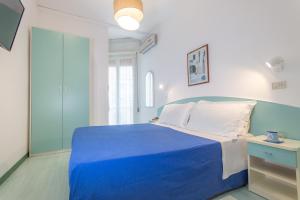a blue and white bedroom with a blue bed at Hotel Lauretta in Bellaria-Igea Marina