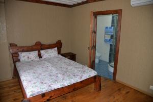 1 dormitorio con cama de madera y baño en Syni Potoky, en Svalyava