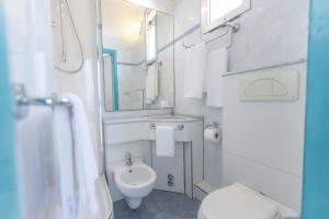 a white bathroom with a toilet and a sink at Hotel Lauretta in Bellaria-Igea Marina