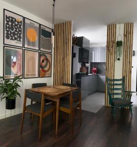 a kitchen and dining room with a wooden table and chairs at Metro Trocka Apartment in Warsaw