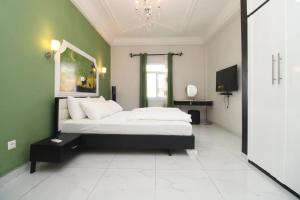 a bedroom with a bed and a green wall at RAP Appart 302 avec piscine in Douala