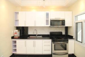 a kitchen with white cabinets and a sink at RAP Appart 302 avec piscine in Douala