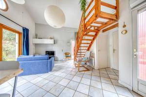 un soggiorno con divano blu e scale di Les chalets de Piqueyrot a Hourtin