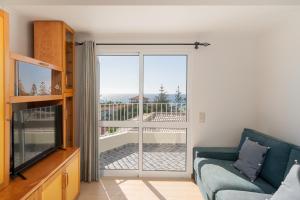 a living room with a couch and a sliding glass door at Fontinha by An Island Apart in Porto Santo