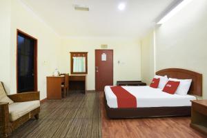 コタバルにあるHotel O Kota Bharu Near War Museum Formerly Azam Hotelのベッドと椅子のあるホテルの部屋