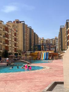 un grupo de personas en una piscina con un parque acuático en الشقق المنفصله فيو اكوا بارك الساحل الشمالي, en El Alamein
