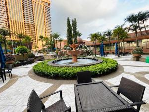 a fountain in the middle of a courtyard with chairs at Better Residence Suite at Times Square KL in Kuala Lumpur