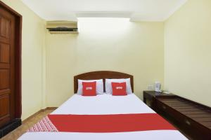 コタバルにあるHotel O Kota Bharu Near War Museum Formerly Azam Hotelの赤い枕が2つ付いたベッドのある寝室