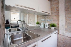 a kitchen with a stainless steel sink and white cabinets at Villa Veli Varos in Split +71 photos