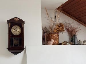 a grandfather clock on a wall next to a vase at Corner house apartment in Montana