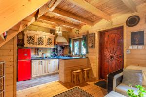 a kitchen with a red refrigerator and a couch in a cabin at Baśniowy Domek in Kościelisko