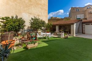 a backyard with a table and chairs on grass at Impero 5 duepiuno in Acquaviva delle Fonti