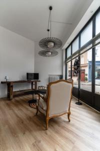 a living room with a chair and a piano at Le Noyer - Maison design dans l'hyper centre in Vichy