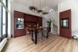 a kitchen with a table and stools at Le Noyer - Maison design dans l'hyper centre in Vichy +49 photos