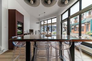 a kitchen with a large wooden table with stools at Le Noyer - Maison design dans l'hyper centre in Vichy