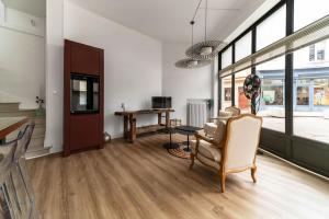 a living room with a chair and a table at Le Noyer - Maison design dans l'hyper centre in Vichy