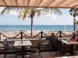 dos personas sentadas en mesas en la playa en MIAMI 06 by Villagrancanaria, en San Bartolomé