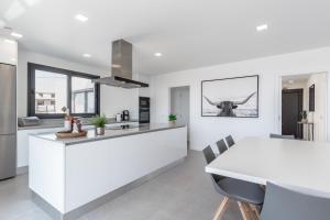 a kitchen with white cabinets and a white table at Dream Villa with ocean view in Lourinhã