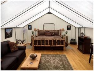 a room with a large bed in a tent at Gorgeous Luxury Tent Rental near Glacier National Park in Montana in Outback Mobile Home Settlement