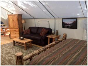 a bedroom with a bed and a couch in a tent at Gorgeous Luxury Tent Rental near Glacier National Park in Montana in Outback Mobile Home Settlement