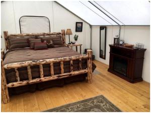 a bedroom with a large wooden bed and a table at Gorgeous Luxury Tent Rental near Glacier National Park in Montana in Outback Mobile Home Settlement