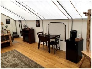 a dining room with a table and chairs in a tent at Gorgeous Luxury Tent Rental near Glacier National Park in Montana in Outback Mobile Home Settlement
