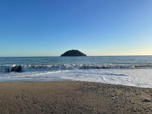 a beach with a small island in the water at Limone Al Mare in Albenga