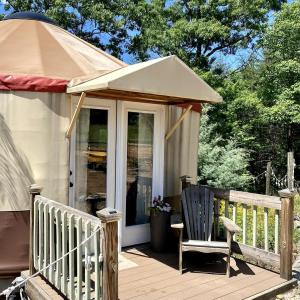 a porch of a house with a chair and a tent at Serenity Yurt in Sunny View