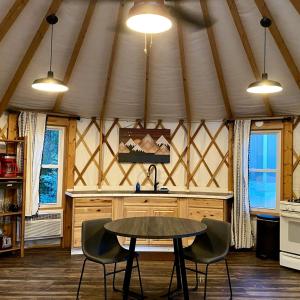 a kitchen with a table and chairs in a tent at Serenity Yurt in Sunny View +2 photos