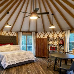a bedroom with a bed and a table in a tent at Serenity Yurt in Sunny View