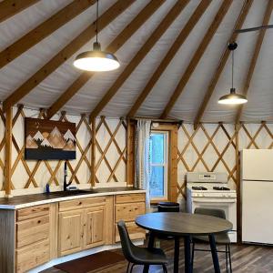 a kitchen with a table and a stove in a room at Serenity Yurt in Sunny View