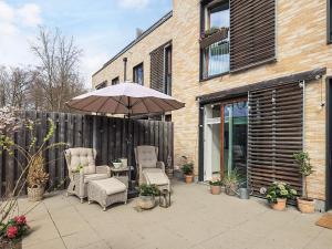a patio with two chairs and a table with an umbrella at 4 star holiday home in Vedbæk in Vedbæk