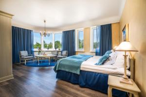 a hotel room with a bed and a table and chairs at Hotel Astor in Vaasa +94 photos