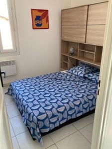 una camera da letto con un letto con un piumone blu di Evasion Marine a Palavas-les-Flots