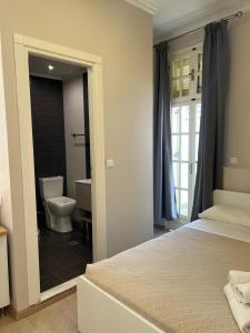 a bedroom with a bed and a bathroom with a toilet at Island Boutique Hotel in Rhodes Town