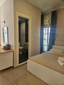 a bedroom with a bed and a bathroom with a mirror at Island Boutique Hotel in Rhodes Town