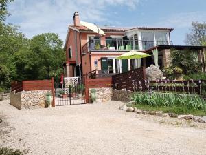 różowy dom z płotem i parasolem w obiekcie The Forest House Krk 1 w mieście Kras
