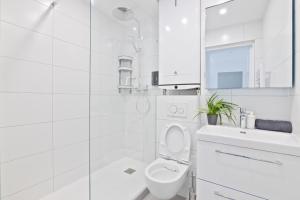 une salle de bain blanche avec toilettes et douche dans l'établissement 1 Bedroom Apartment Quartier Austerlitz Free Netflix, à Paris 8 autres photos