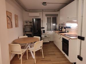 a kitchen with a wooden table and white cabinets at El Pisito in Ontinyent