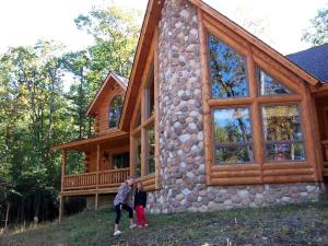 duas pessoas em frente a uma casa em Rustic Log Cabin in the Catskills, Upstate New York em Olivebridge