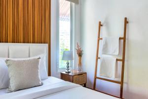 a bedroom with a bed and a window at 提供免费汽车使用的含泳池被墅房间 in Chiang Mai