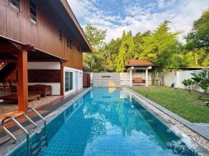 a swimming pool in the backyard of a house at 提供免费汽车使用的含泳池被墅房间 in Chiang Mai