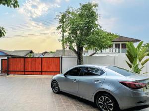 a silver car parked in front of a house at 提供免费汽车使用的含泳池被墅房间 in Chiang Mai