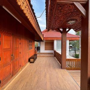 an empty porch of a house with wooden doors at 提供免费汽车使用的含泳池被墅房间 in Chiang Mai
