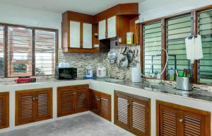 a kitchen with wooden cabinets and a counter top at 提供免费汽车使用的含泳池被墅房间 in Chiang Mai