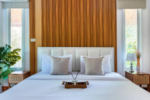 a bedroom with a large white bed with a gold wall at 提供免费汽车使用的含泳池被墅房间 in Chiang Mai