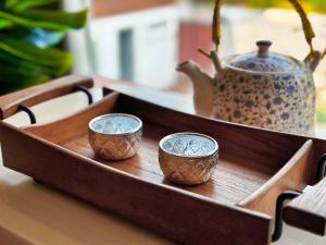 a wooden tray with three small cups and a vase at 提供免费汽车使用的含泳池被墅房间 in Chiang Mai
