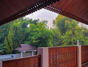 a balcony with a wooden fence and trees at 提供免费汽车使用的含泳池被墅房间 in Chiang Mai